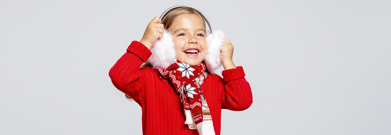 Little girl wearing earmuffs, a sweater, and a scarf