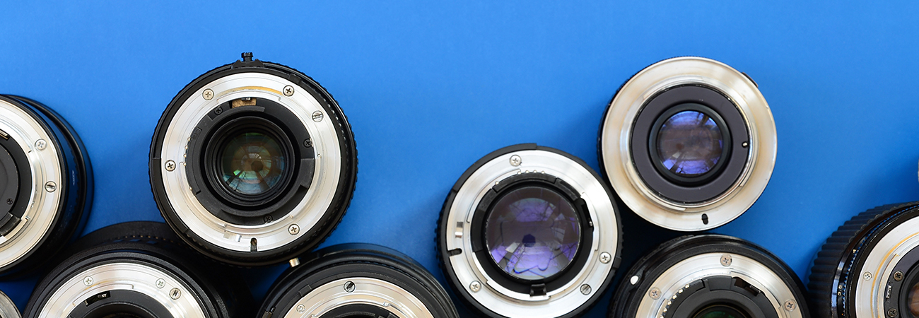 An assortment of camera lenses on a blue background