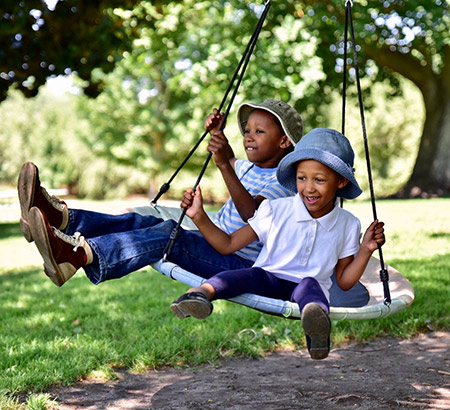 Two boys in bucket hats on a swing