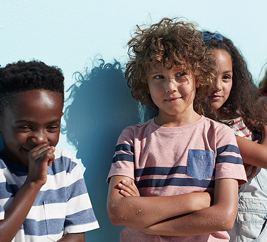 Middle school age kids standing in front of a wall