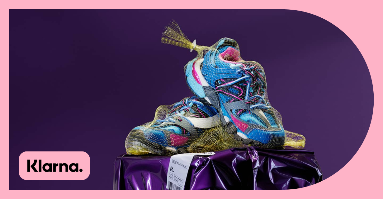 Klarna的标志和一双亮蓝色和粉红色的运动鞋在一个网状水果袋.