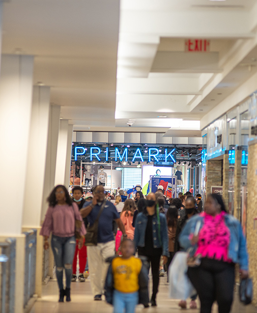 Primark storefront with a crowd of shoppers walking toward the camera