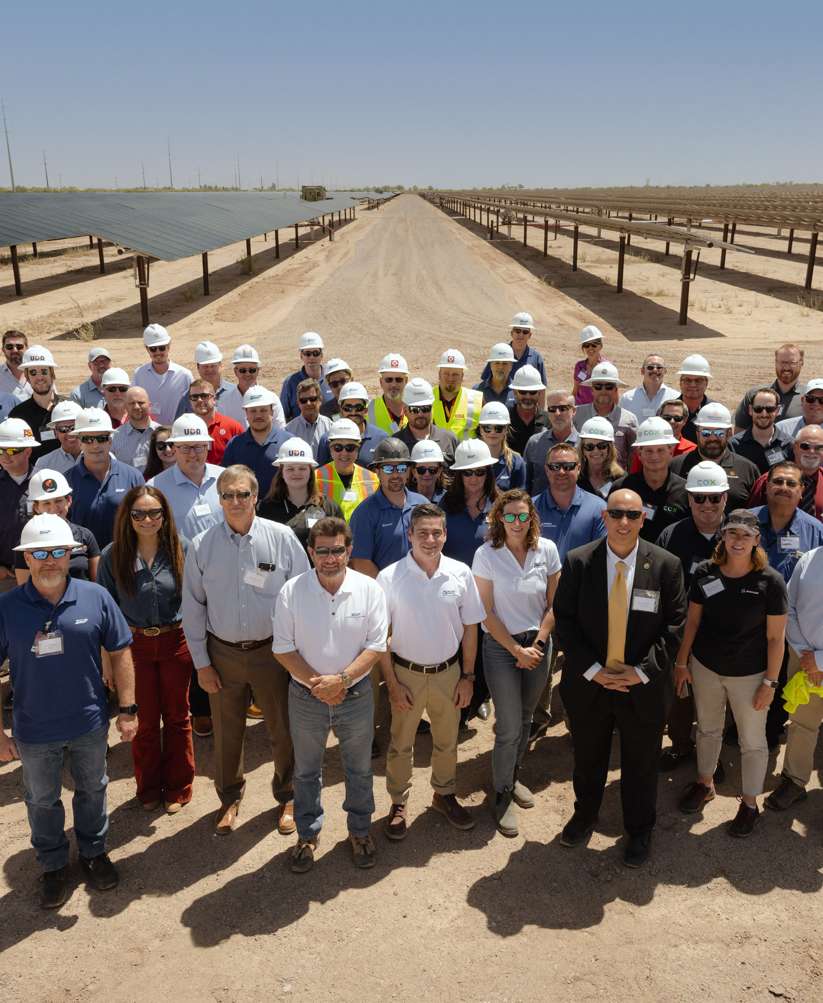 A large group of people standing in front of solar panels