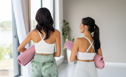 two women with yoga mats 