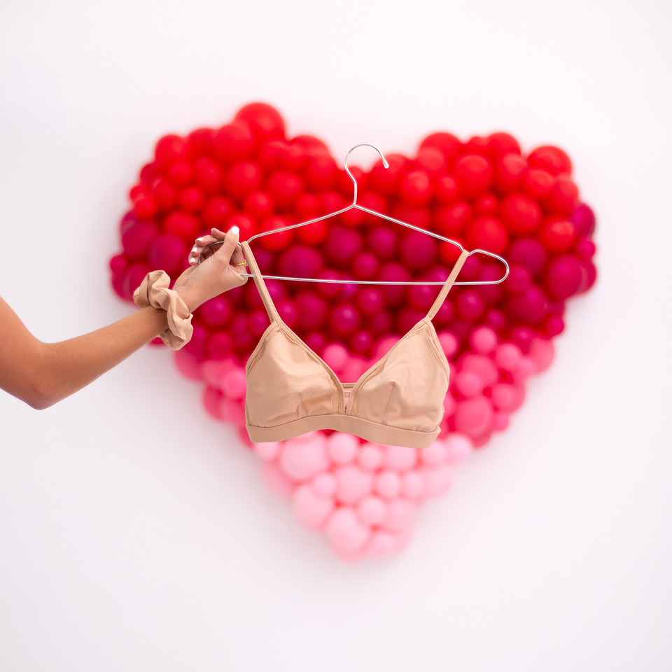 Hand holding a nude bra