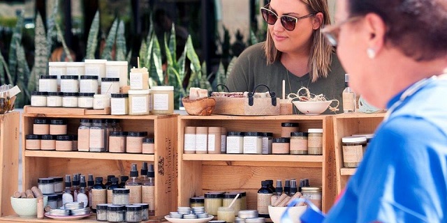 Woman attending fair and looking at crafts. 