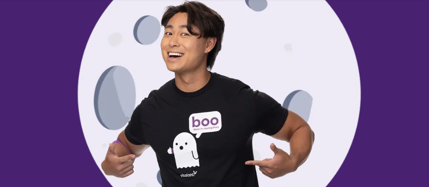 Guy wearing a black shirt with a white ghost on it that says BOO and the Vitalant logo. 