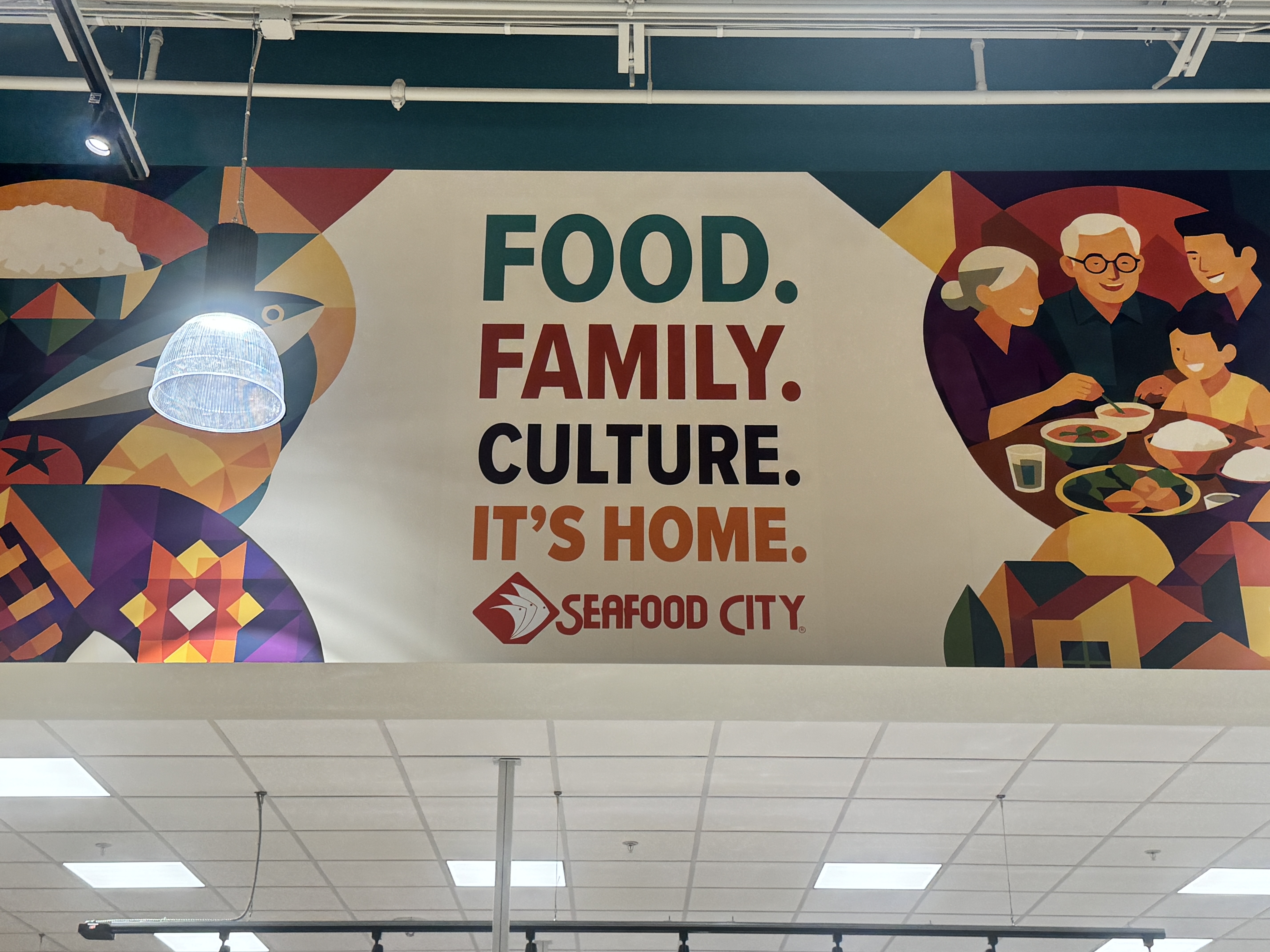 Mural on wall that says Food. Family. Culture. It's Home. Seafood City. 