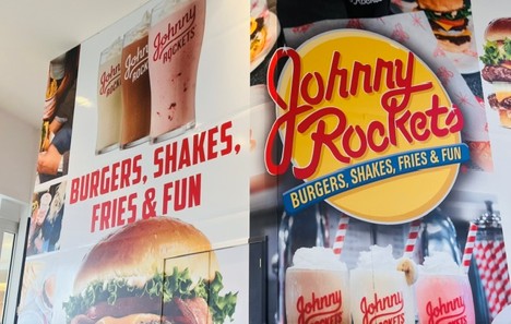 Barricade with burgers, shakes, French fires and the Johnny Rockets logo that says Burgers, Shakes, Fries & Fun". 