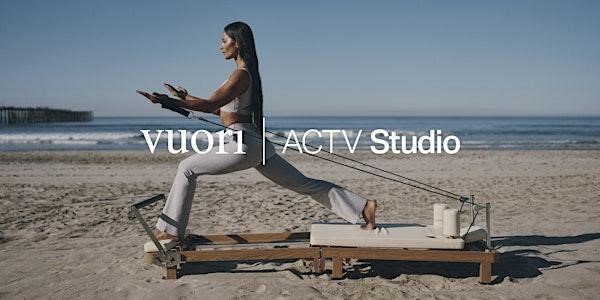 Lady on a Pilates machine on the beach wearing Vuori clothing. Image says, "Vuori | ACTV Studio" 