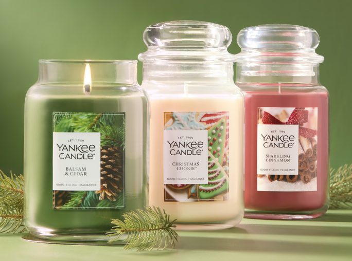 A green, white and red Yankee Candle. Green says Yankee Candle, Balsam & Cedar. White says Yankee Candle, Christmas Cookie. Red says Yankee Candle, Sparkling Cinnamon. 