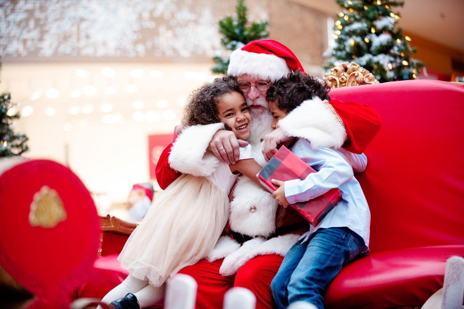 Santa hugging a boy and girl