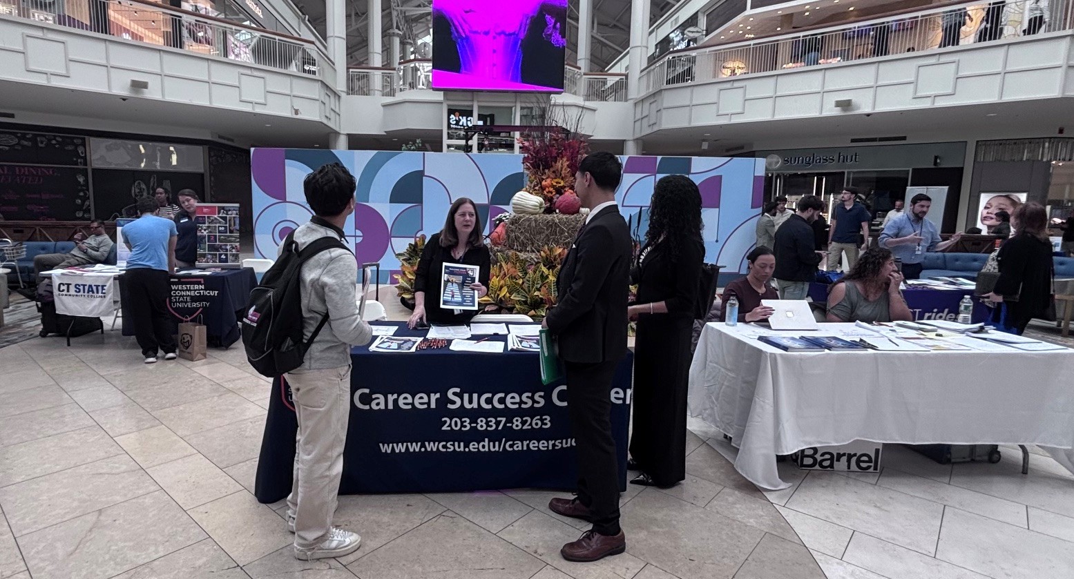 Job seekers meeting with employers at tables during a career fair.