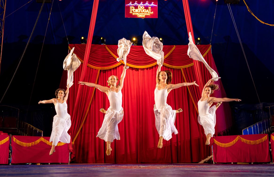 4 women in white leaping