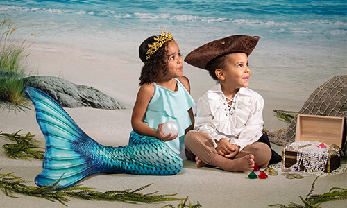 Little girl dressed as mermaid and boy dressed as pirate