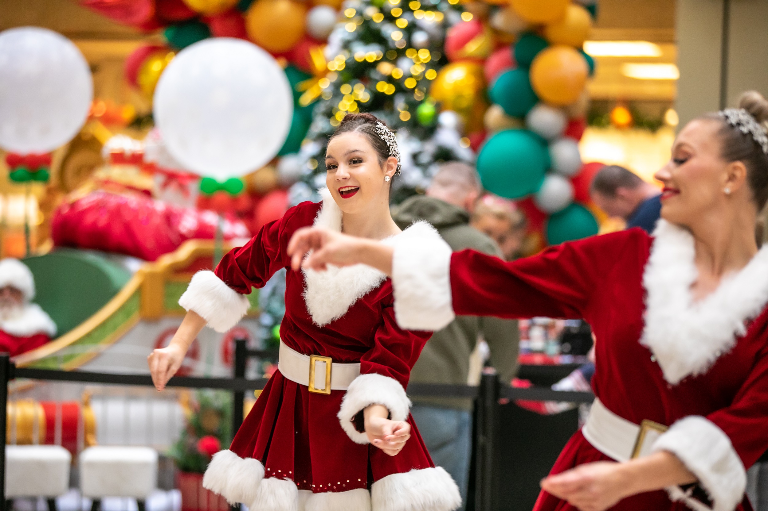 Two women dancing in Santa dresses