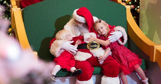 Santa hugging two small children