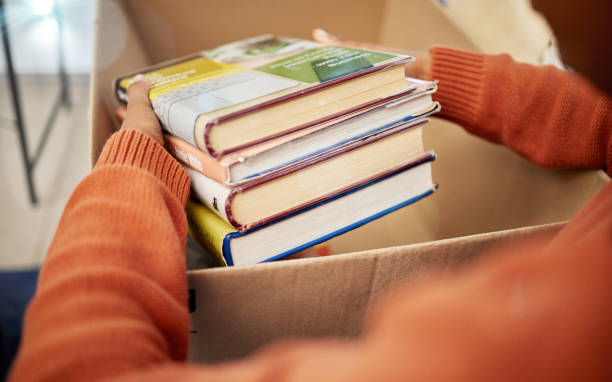 hands placing books in a box