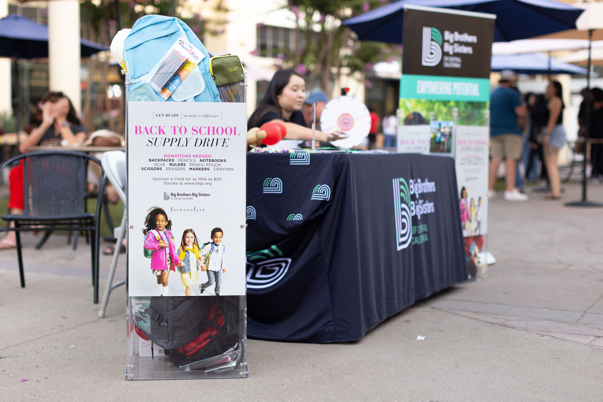 Big Brothers Big Sisters display table with full donation bin