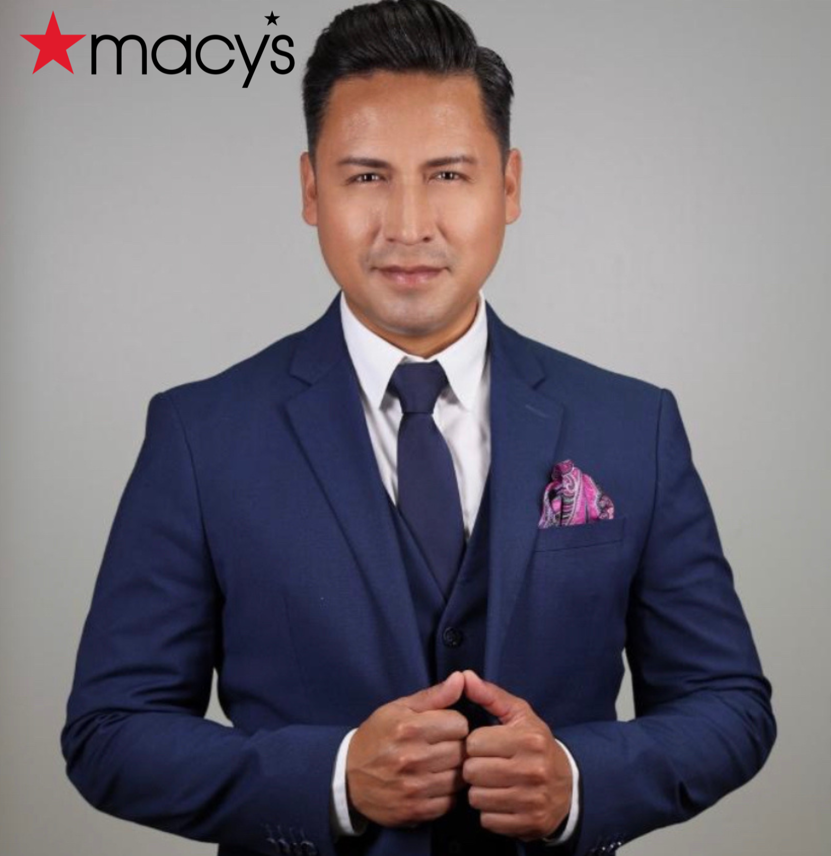 Man wearing a blue suit looking at the camera and smiling