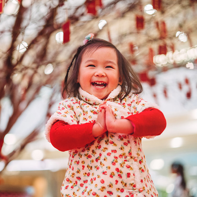 Happy toddler with a giving tree in the background