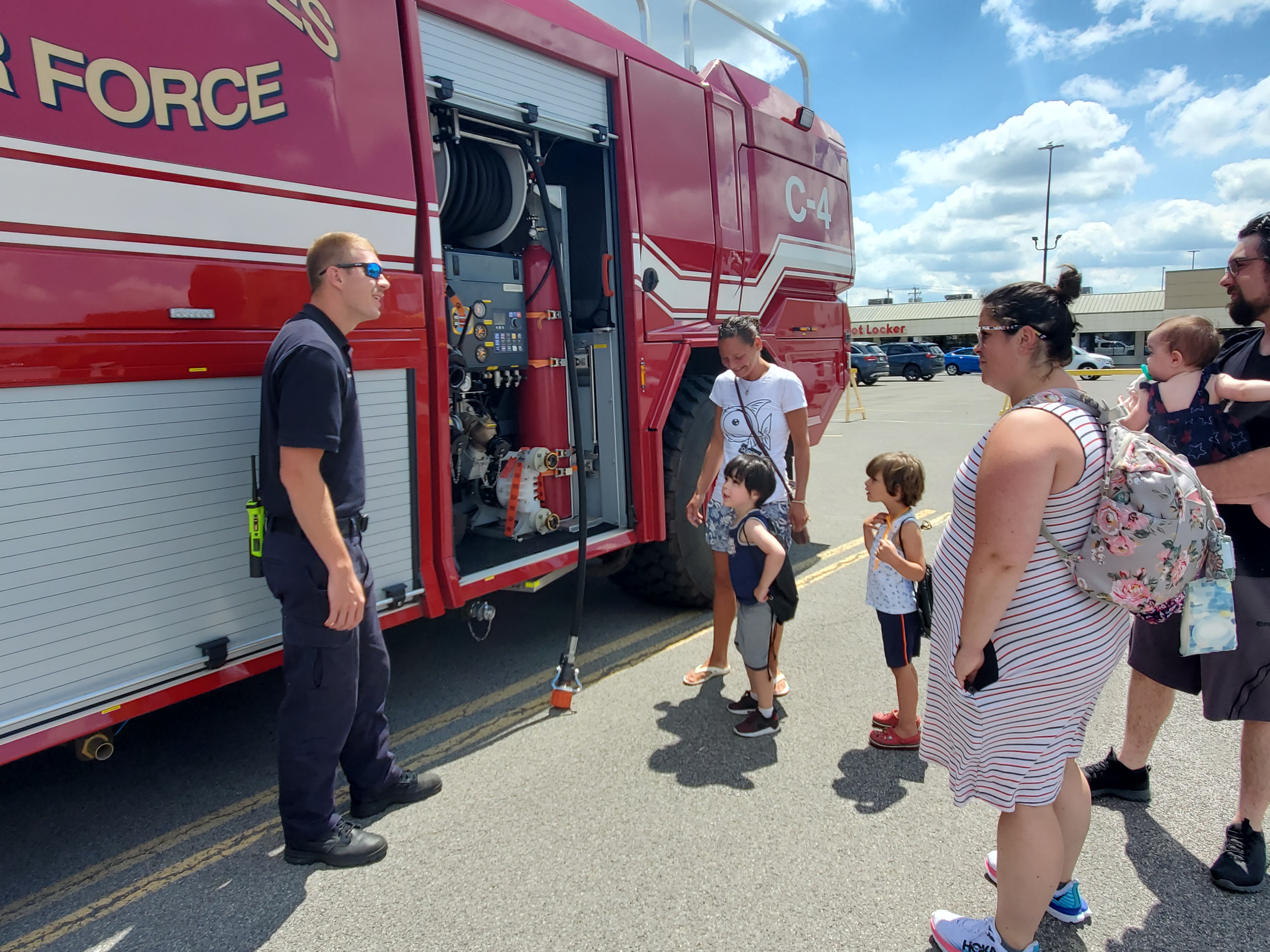 Families interacting with a firefighter at a previous Touch-a-Truck event, at Fashion Outlets of Niagara Falls USA.