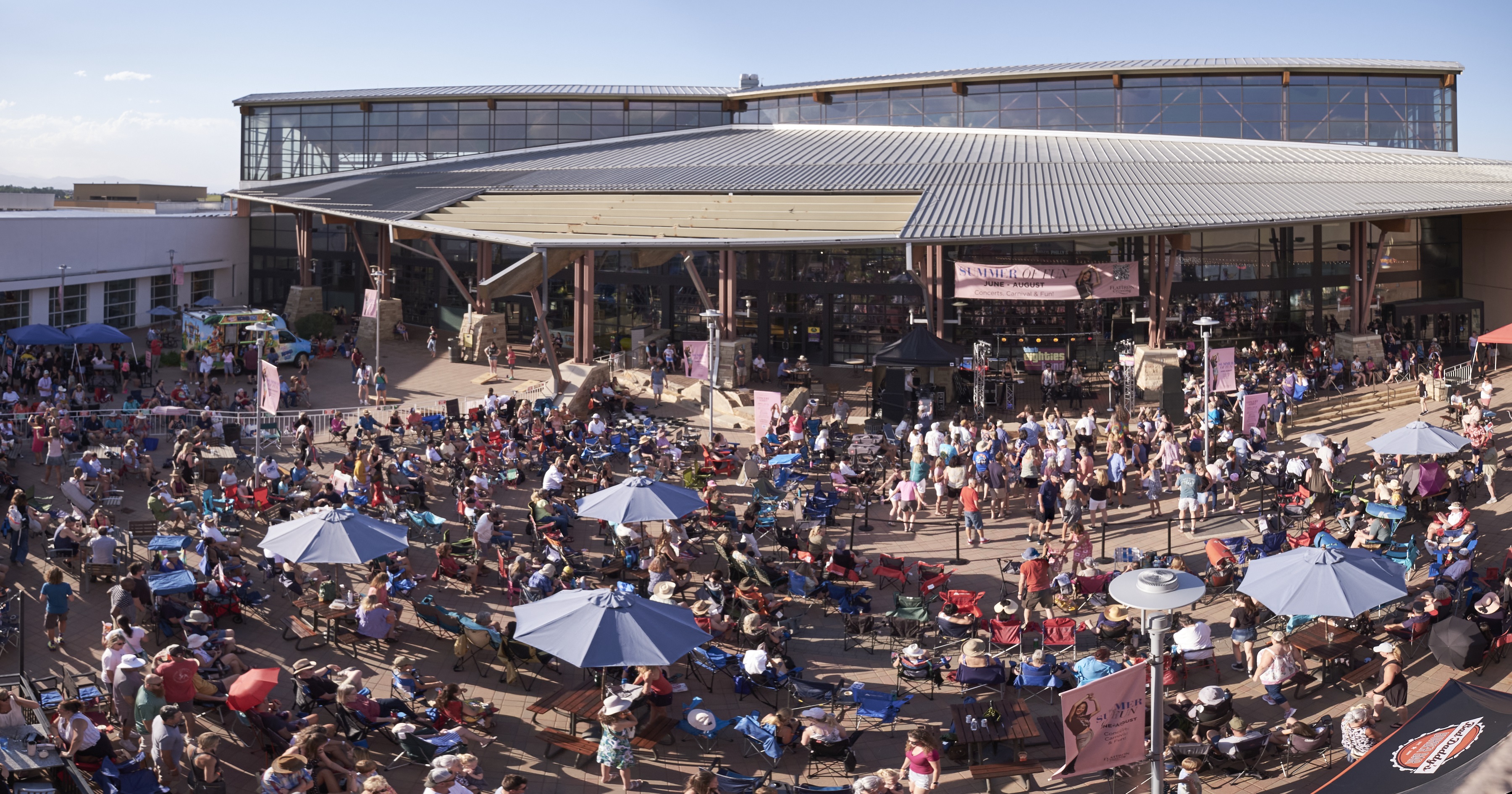Concert crowd with large building in the background.