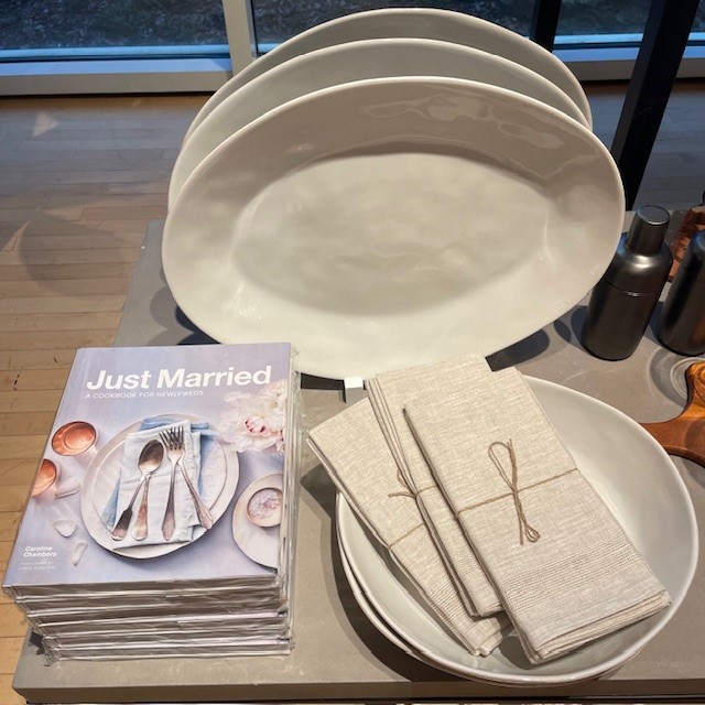 Stack of Just Married books with white plates and cloth napkins on a table.