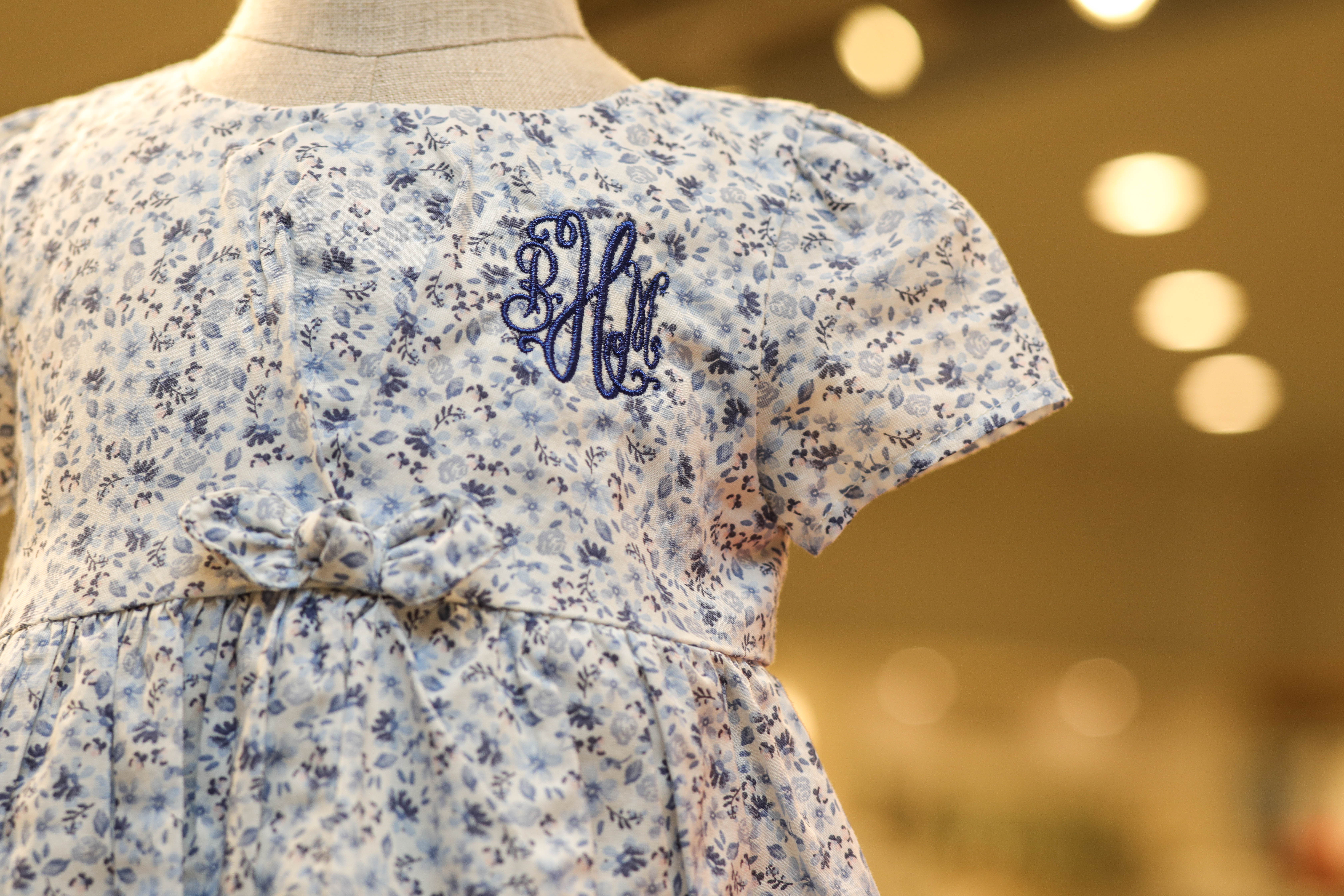 Child's blue flowered dress with monogramed initials. 