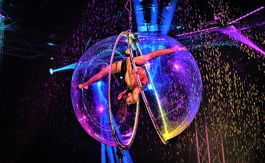 Circus performer who is performing acrobatics in a bubble