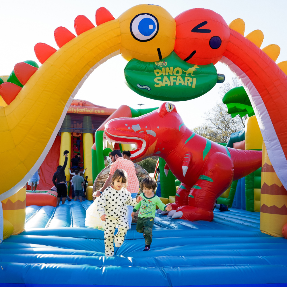 Children playing in a dinosaur bounce house