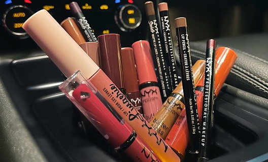 NYX makeup products in a car cup holder