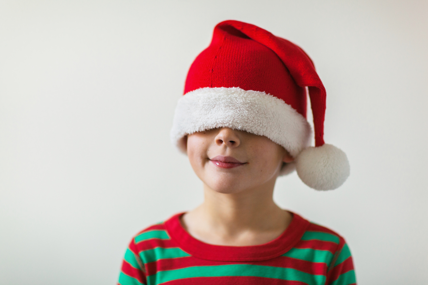 Child wearing Pajamas and wearing a Santa Hat