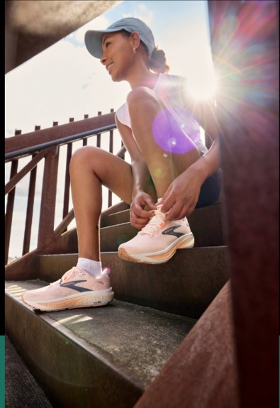 Woman sitting on stairs tying her shoe