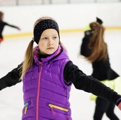 Child in a purple coat ice skating