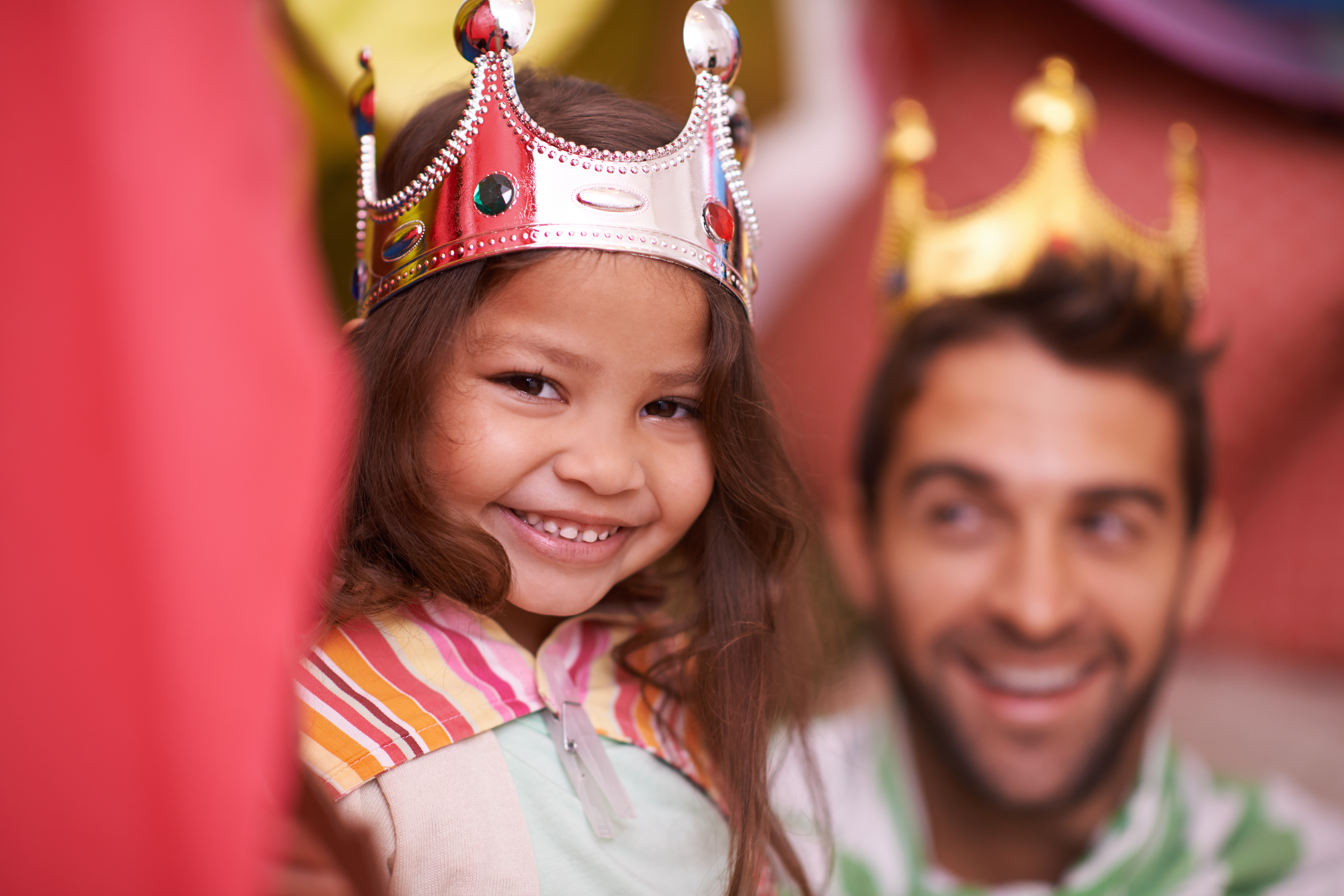 Child and dad wearing crowns and capes