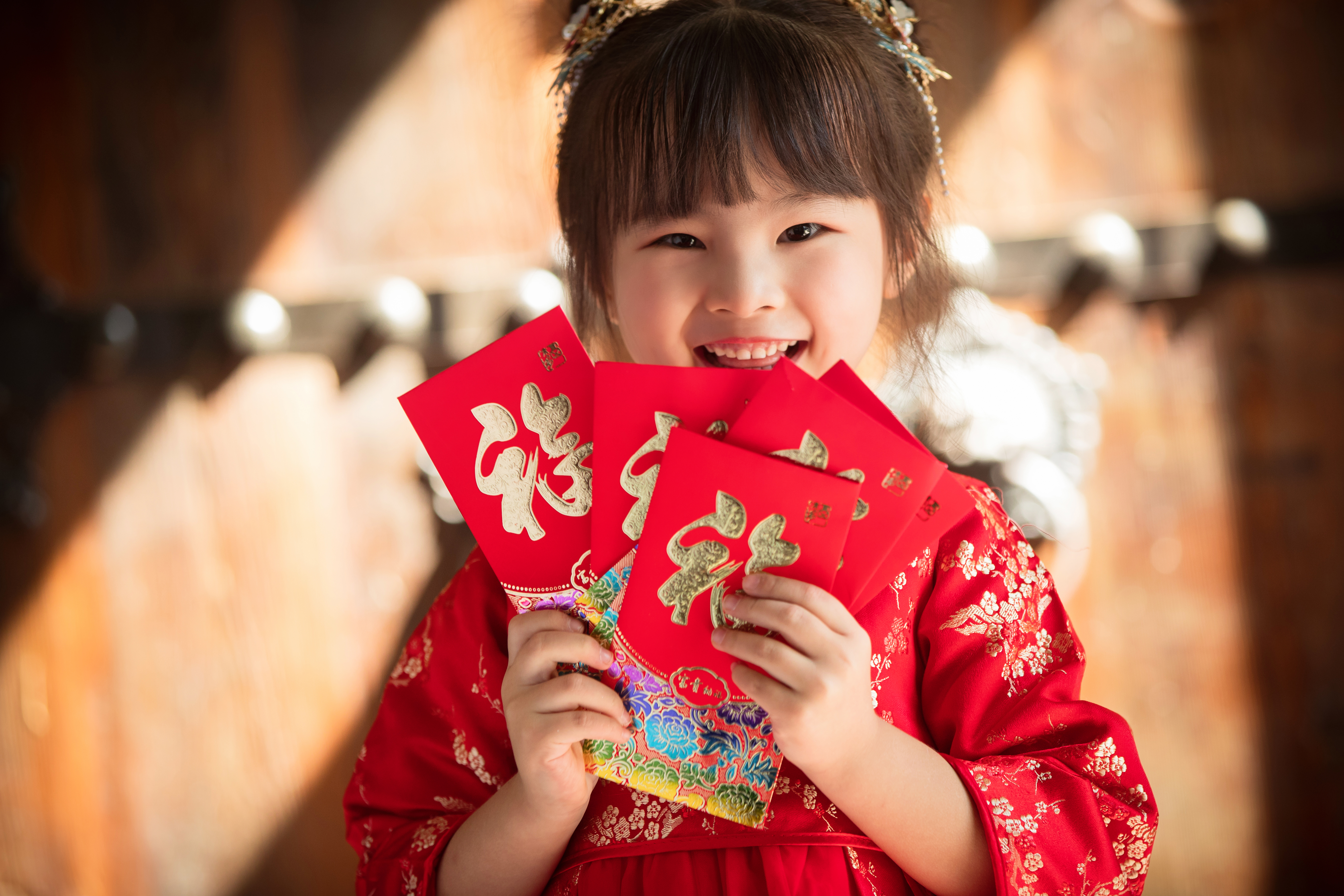 little girl with red cultural lunar new year outfit with red envelopes 