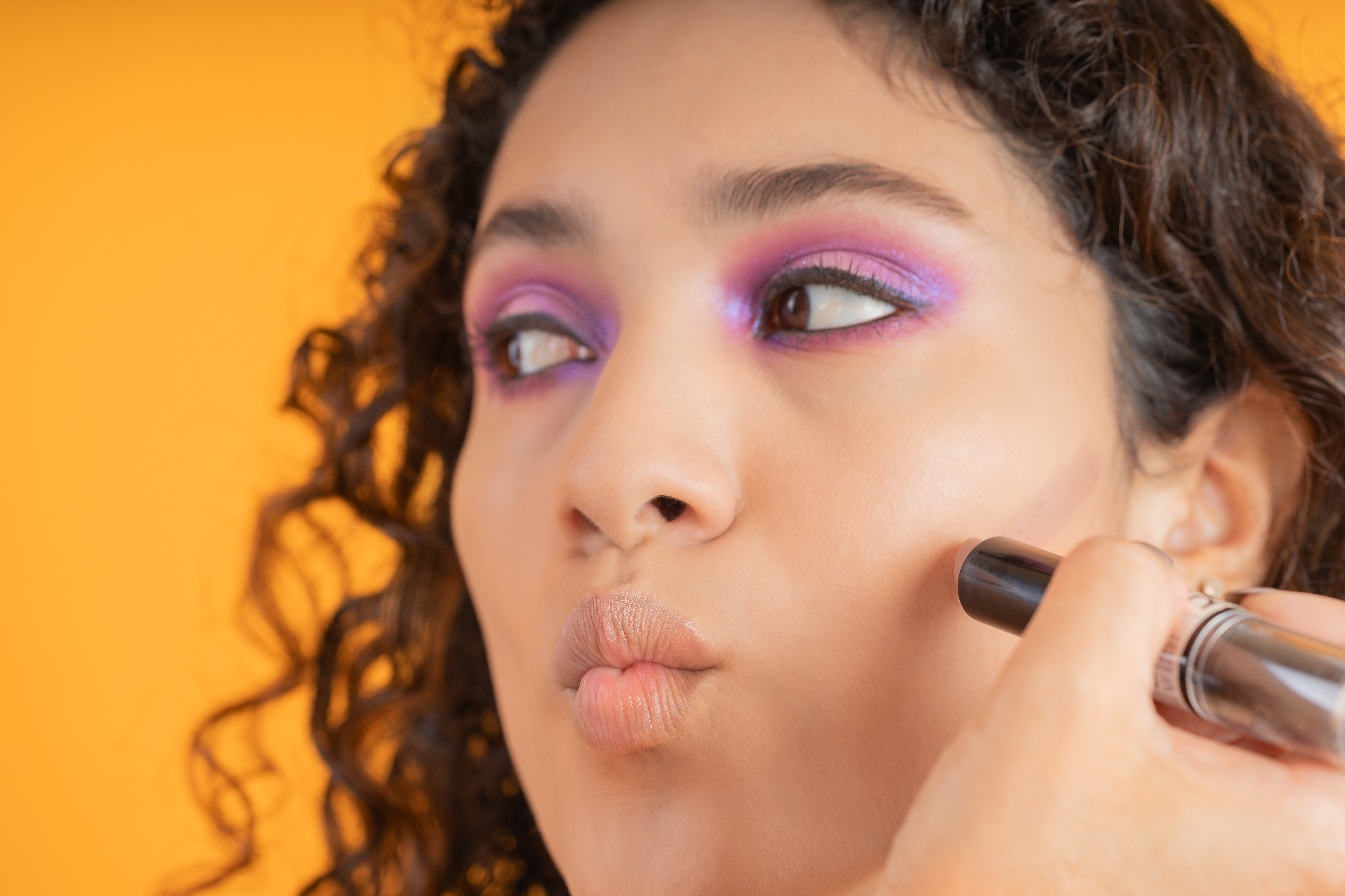 Someone applying make-up to a woman's face.