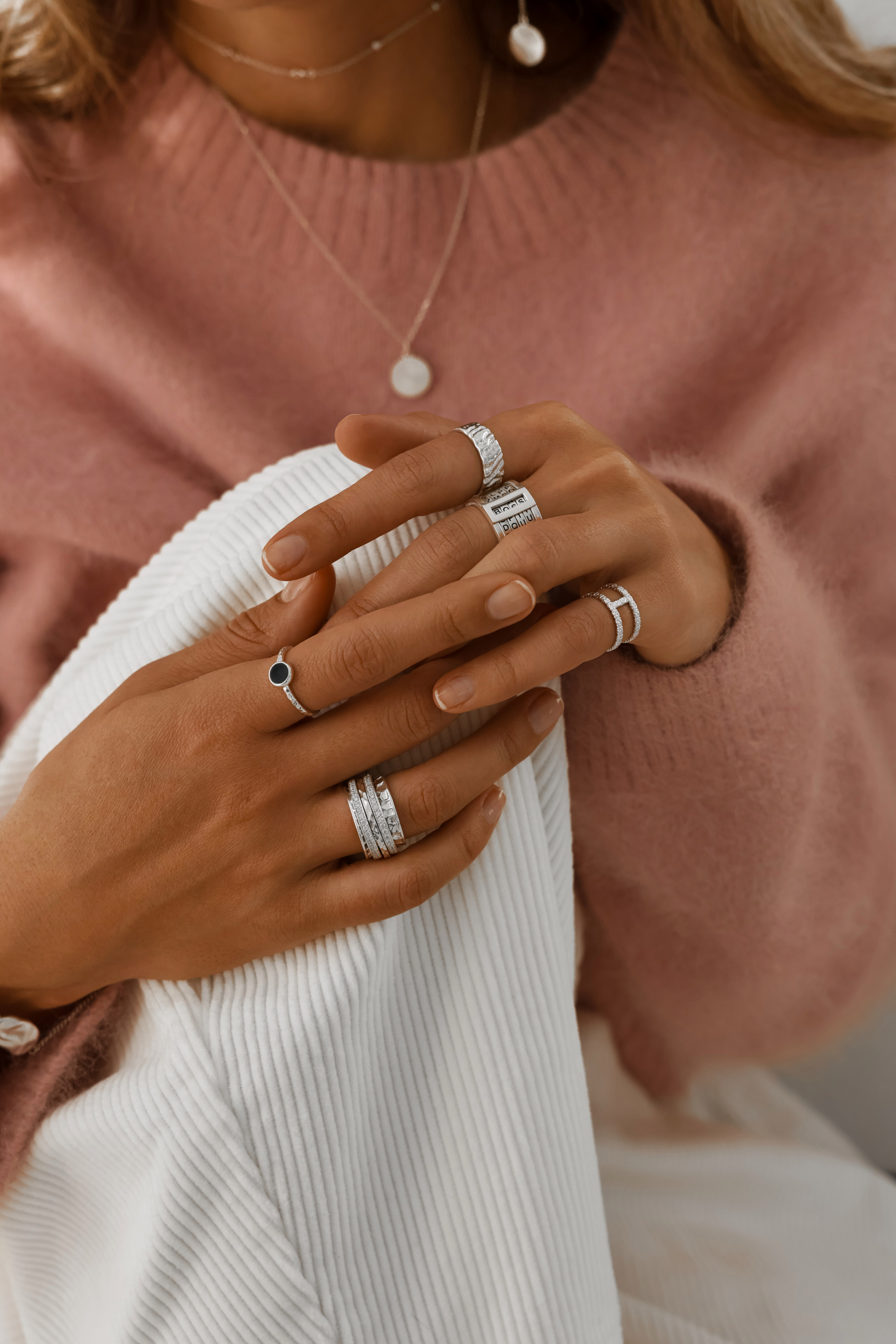 a person's with necklaces, bracelets, and rings 