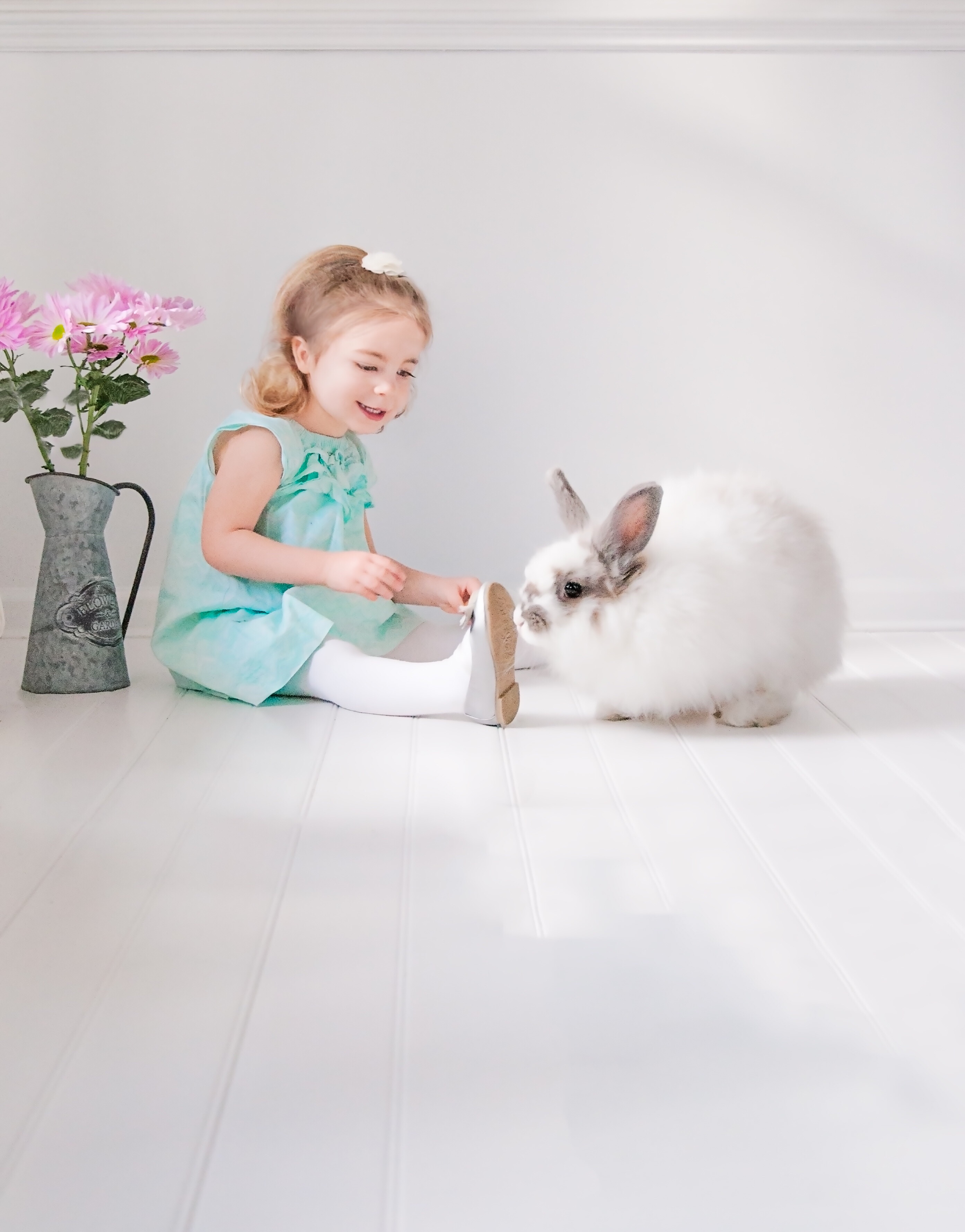 Little girl with a bunny sitting on the floor