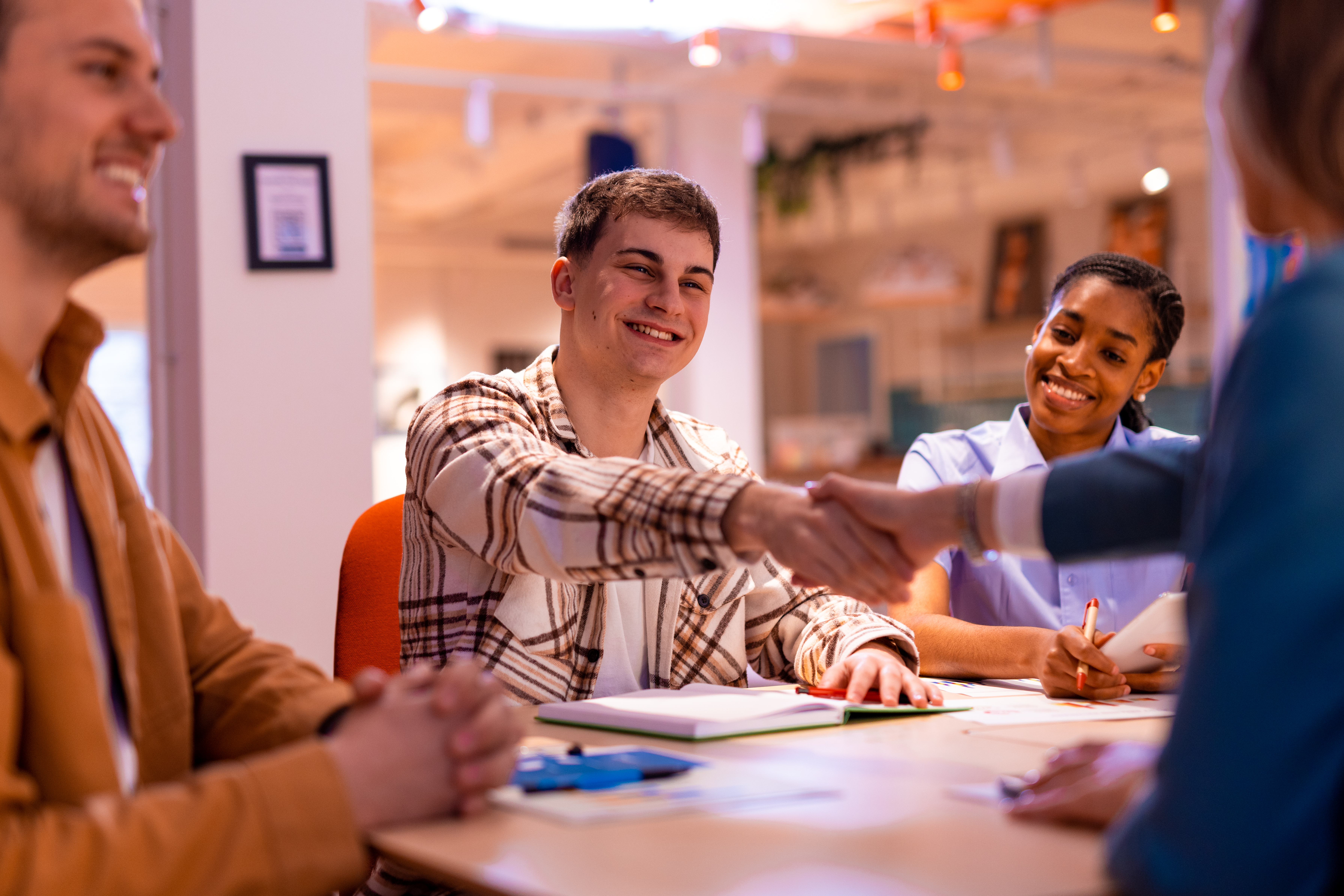 Business associates at a table shaking hands