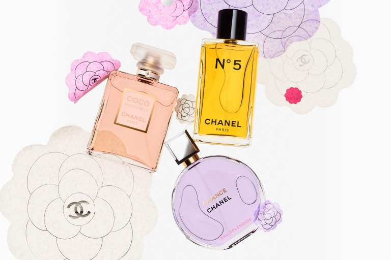 Three Chanel perfume bottle against a soft white background. 