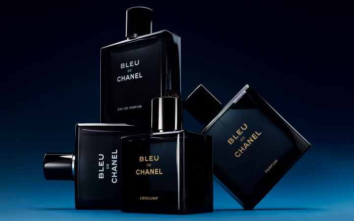 Four Bleu de Chanel fragrance bottles displayed on a dark blue background.