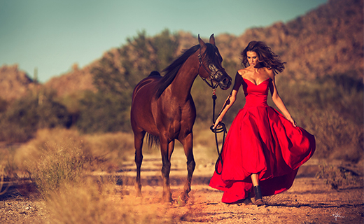 Woman in red dress next to a horse
