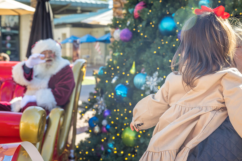 Santa waiving to a girl.