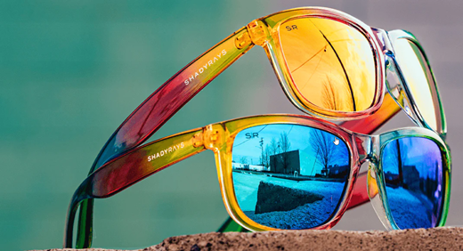 Two pairs of sunglasses stacked on top of each other.