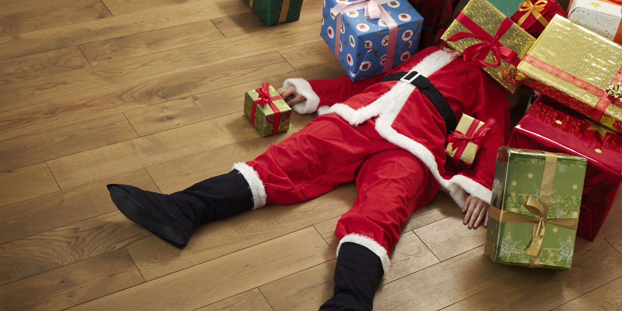 Santa buried under Christmas presents 