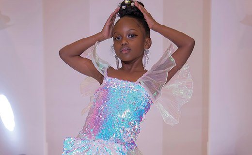 Kid model posing on the runway in a colorful sequin dress,