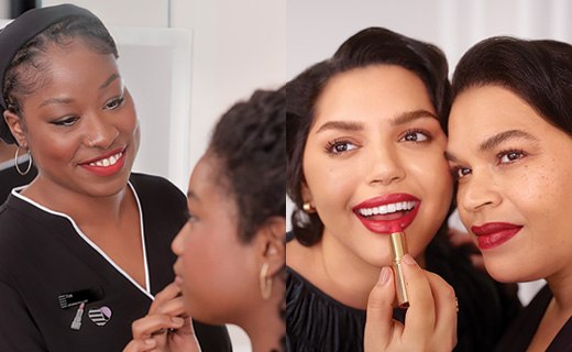 Four women with one applying makeup on another and one applying lipstick while the other looks on.