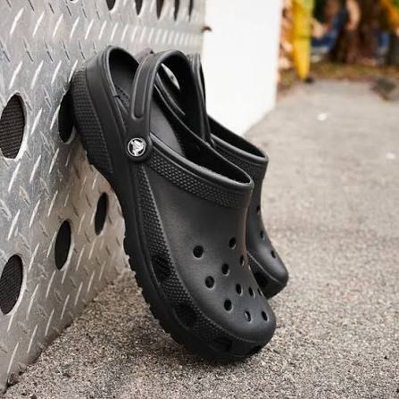 black crocs leaning against wall